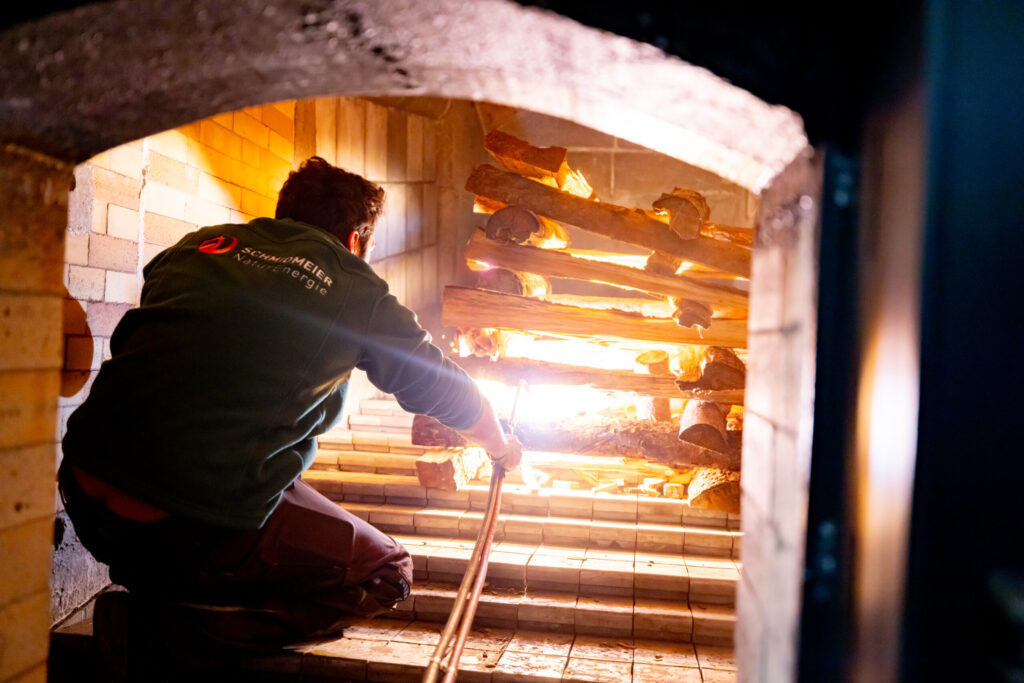Ein Mitarbeiter der Schmidmeier NaturEnergie beim Anheizen der zweiten Biomasseanlage in Feulersdorf